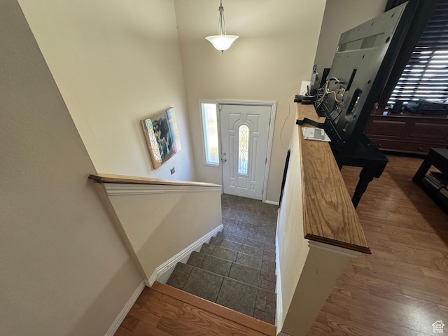 entryway with baseboards and a towering ceiling