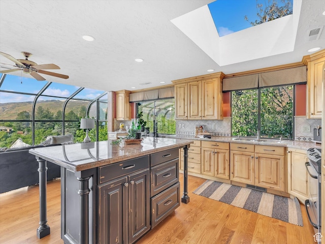 kitchen featuring light wood-style flooring, a sink, stainless steel electric range oven, backsplash, and recessed lighting