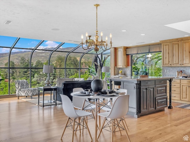 dining space with light wood-style flooring, a chandelier, and recessed lighting