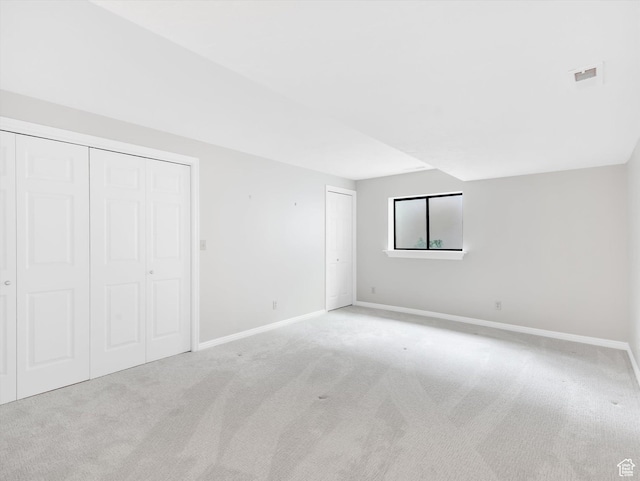 unfurnished bedroom with carpet, baseboards, and two closets