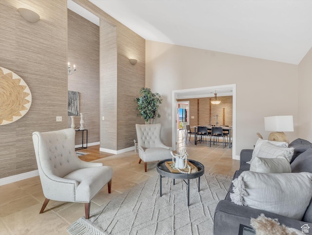 tiled living area featuring baseboards and high vaulted ceiling