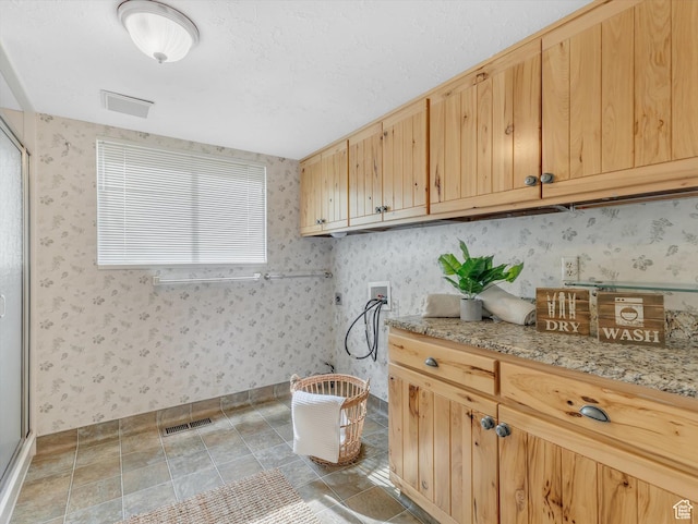 laundry area with hookup for a washing machine, cabinet space, wallpapered walls, and baseboards