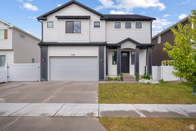 view of front of house featuring a garage, concrete driveway, and a gate