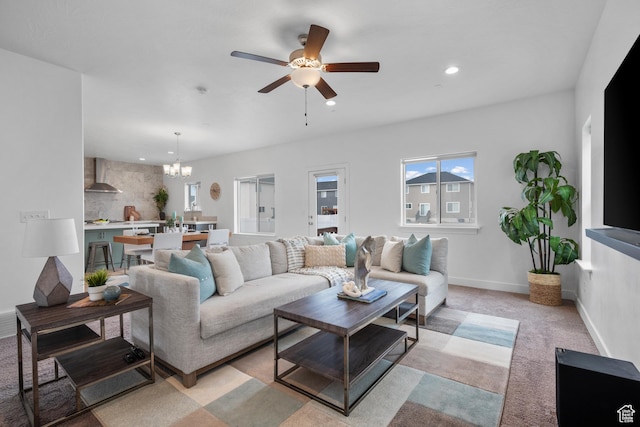 living room with a chandelier, ceiling fan, recessed lighting, light colored carpet, and baseboards