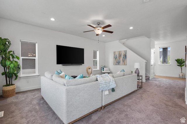 carpeted living area featuring stairs, a ceiling fan, recessed lighting, and baseboards