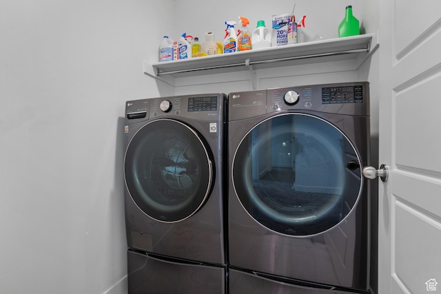 clothes washing area with washer and clothes dryer
