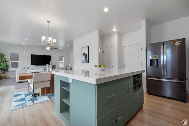 kitchen featuring stainless steel fridge, a chandelier, light wood-style flooring, a kitchen island, and recessed lighting
