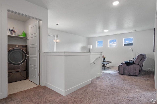 hall with washer / dryer, an upstairs landing, carpet, and baseboards