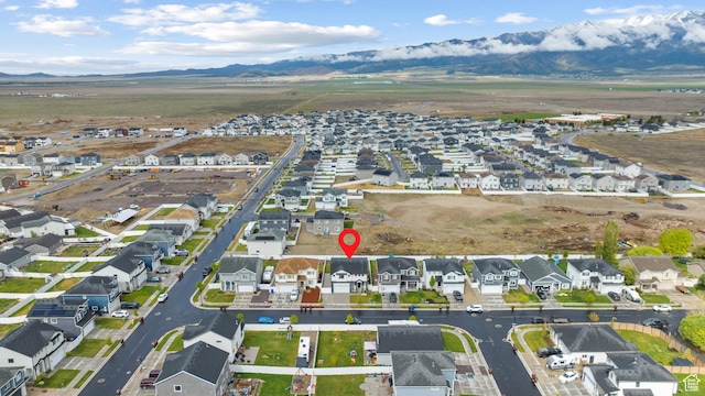 aerial view of property and surrounding area with a mountain backdrop and nearby suburban area