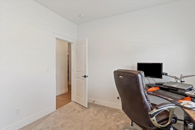 carpeted office space featuring baseboards