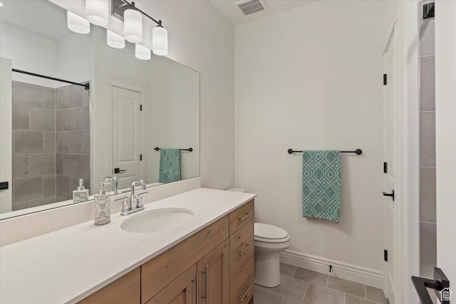 bathroom with tile patterned flooring, toilet, vanity, baseboards, and a shower