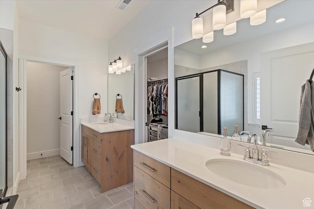 full bathroom with a shower stall, two vanities, tile patterned flooring, and a walk in closet