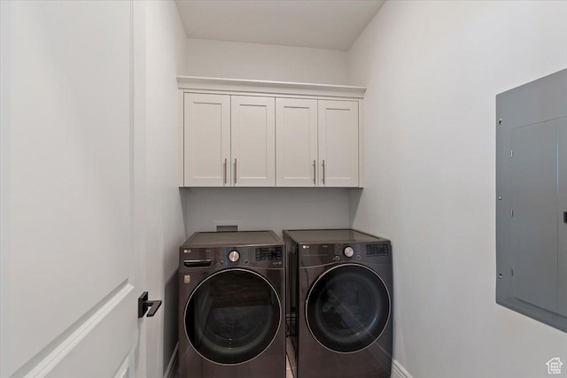 laundry room featuring separate washer and dryer, electric panel, cabinet space, and baseboards