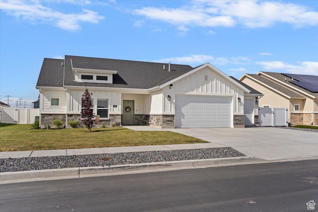 modern inspired farmhouse featuring a gate, stone siding, board and batten siding, and a garage