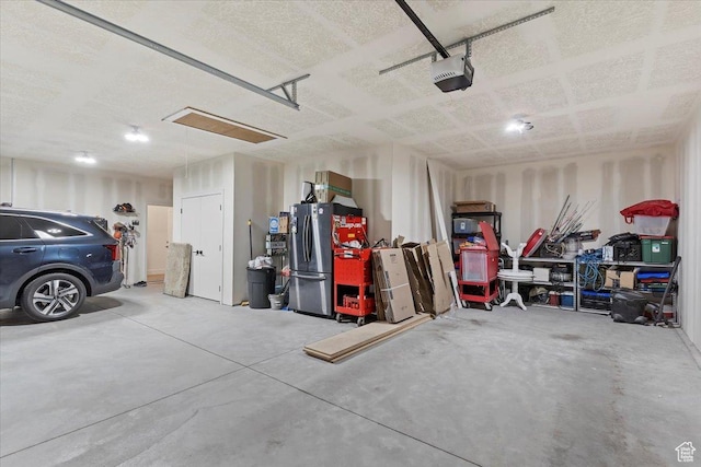 garage featuring freestanding refrigerator and a garage door opener