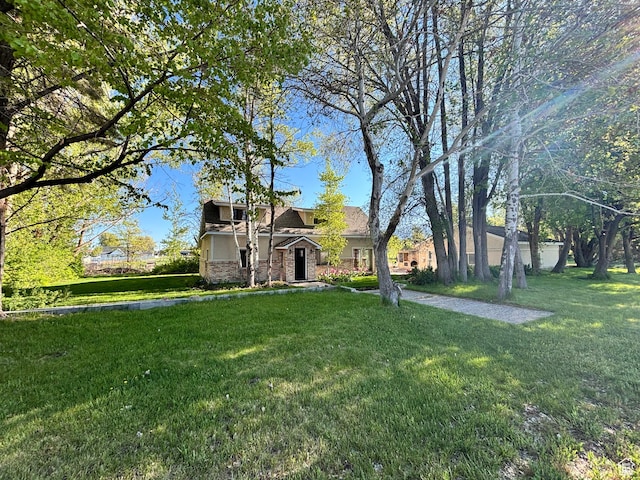 view of front facade with stone siding and a front lawn