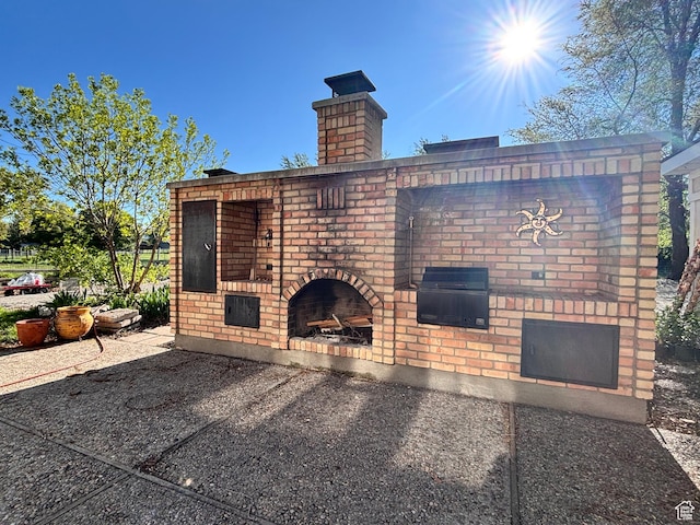view of patio featuring an outdoor brick fireplace