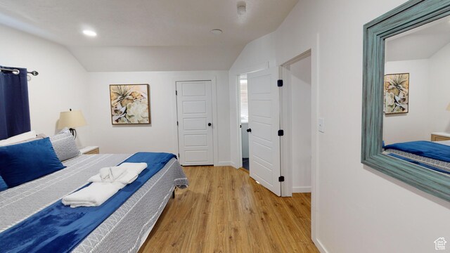 bedroom with vaulted ceiling, light wood finished floors, baseboards, and recessed lighting