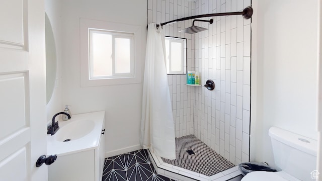 full bathroom featuring a stall shower, toilet, vanity, and tile patterned floors