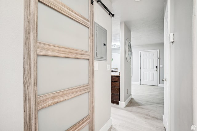 corridor featuring baseboards and electric panel