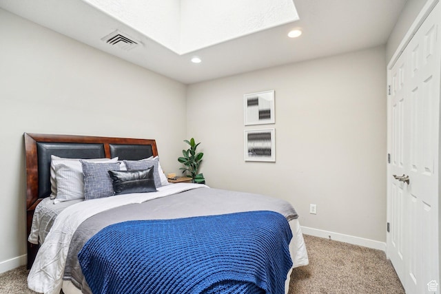 bedroom featuring carpet floors, a skylight, baseboards, recessed lighting, and a closet