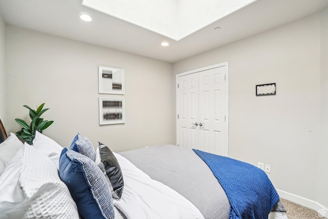 bedroom featuring recessed lighting, a skylight, carpet flooring, baseboards, and a closet