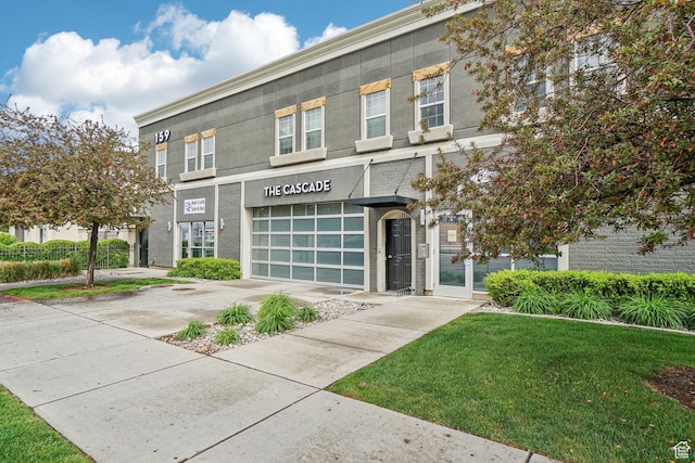 view of front facade with concrete driveway, a front yard, and an attached garage