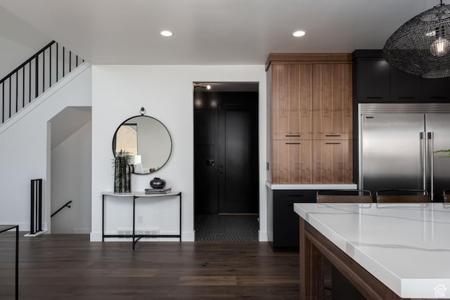 kitchen featuring stainless steel built in refrigerator, dark wood-type flooring, recessed lighting, and baseboards