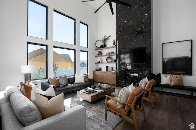 living room with a high ceiling, wood finished floors, and a ceiling fan