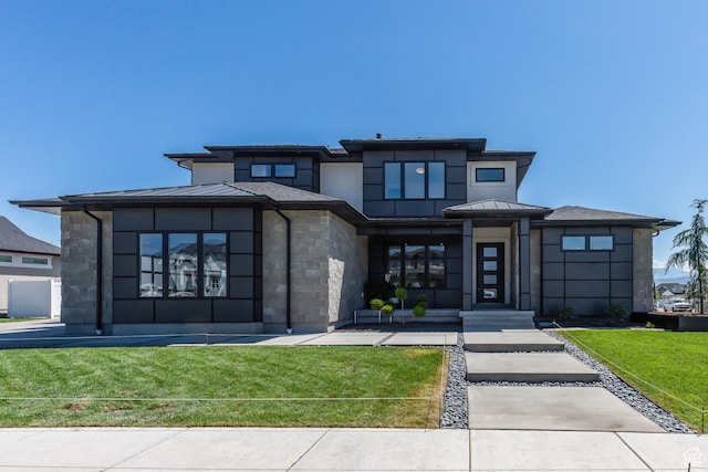 prairie-style home with a standing seam roof, stone siding, and stucco siding