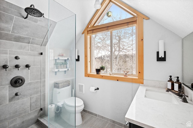 bathroom featuring vaulted ceiling, tiled shower, toilet, vanity, and baseboards