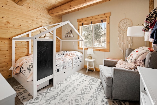 carpeted bedroom with wood ceiling, beam ceiling, and wooden walls