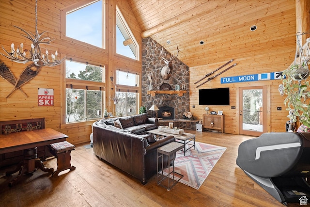 living room featuring high vaulted ceiling, a chandelier, wood-type flooring, wood walls, and beam ceiling