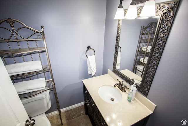 bathroom featuring toilet, baseboards, and vanity