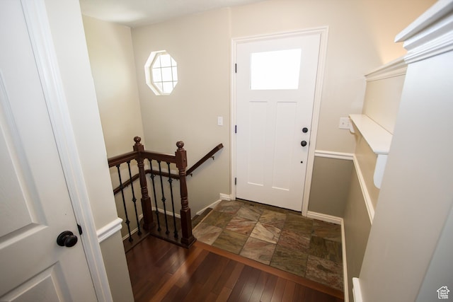 entrance foyer featuring baseboards and dark stone finish flooring