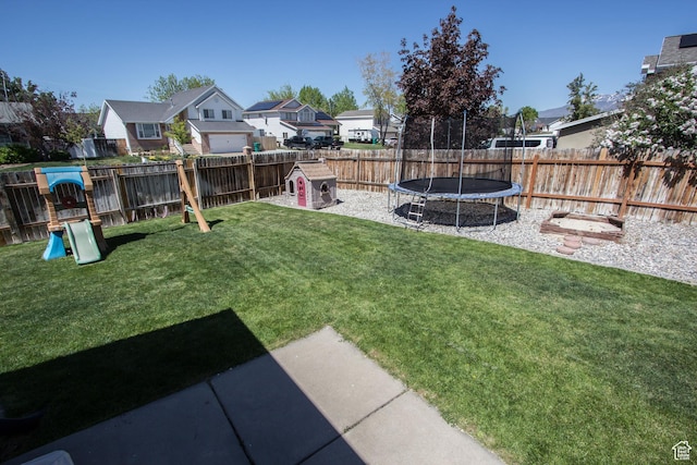 view of yard featuring a residential view, a trampoline, and a playground