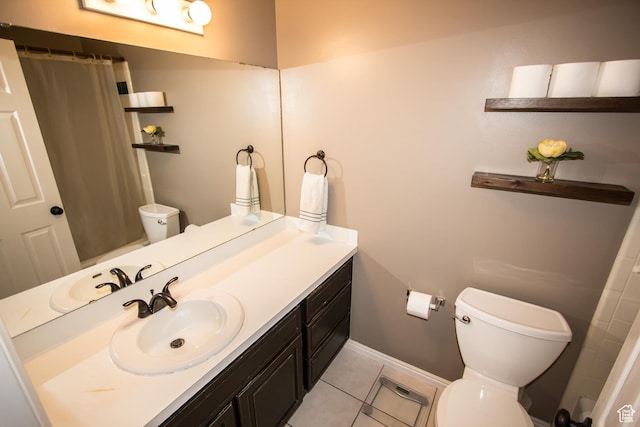 bathroom featuring toilet, tile patterned floors, vanity, baseboards, and a shower with curtain