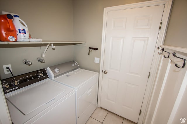 laundry area with washer and clothes dryer and light tile patterned floors