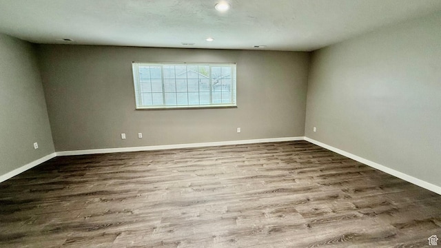 unfurnished room featuring wood finished floors, baseboards, and recessed lighting