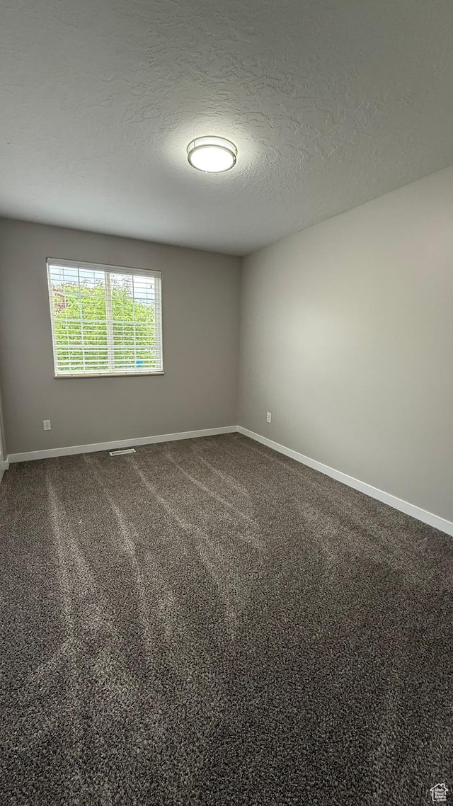 unfurnished room with baseboards, a textured ceiling, and carpet floors