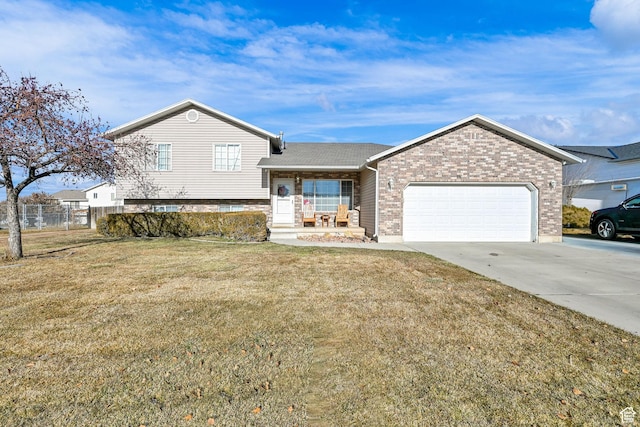 split level home with driveway, brick siding, a garage, and covered porch