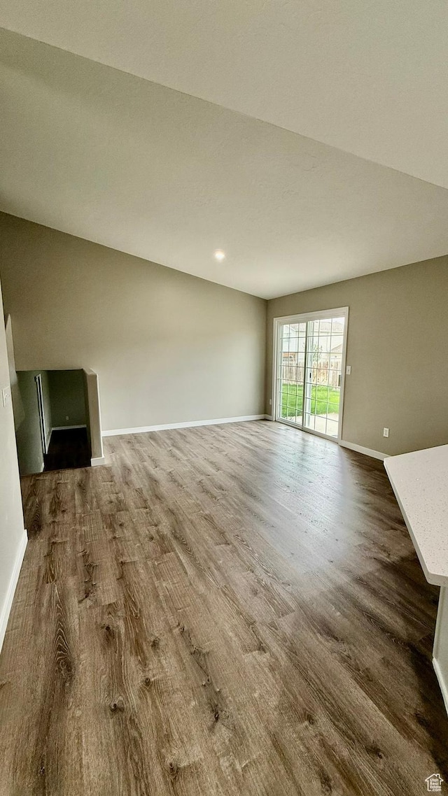 unfurnished living room featuring wood finished floors and baseboards