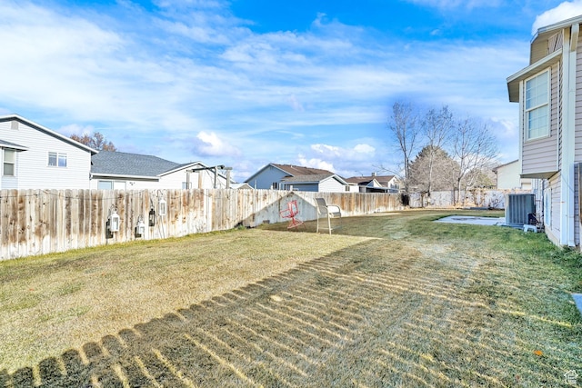 view of yard with a residential view and central air condition unit