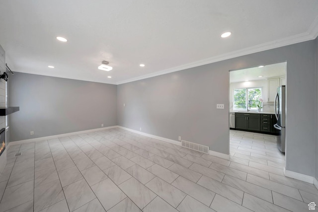 unfurnished living room featuring recessed lighting, crown molding, baseboards, a sink, and light tile patterned floors