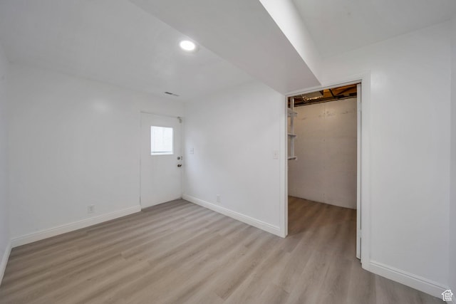 below grade area with light wood finished floors, recessed lighting, and baseboards