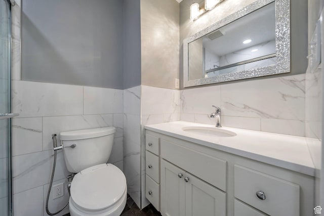 bathroom featuring tile walls, vanity, toilet, and an enclosed shower