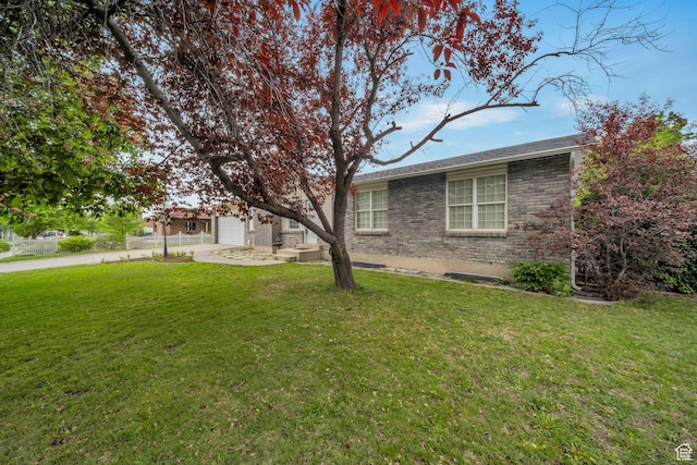 view of grassy yard with concrete driveway and a garage