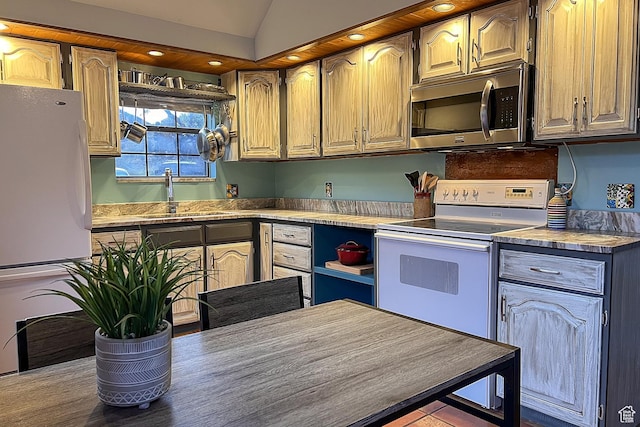 kitchen featuring white appliances, a sink, vaulted ceiling, and recessed lighting
