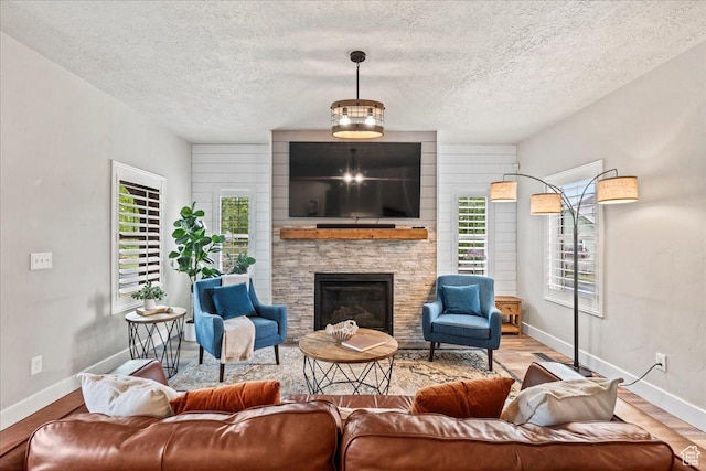5153 W Bowstring Way S, Jordan, UT 84009 - living room with a textured ceiling, baseboards, wood finished floors, a fireplace, and healthy amount of natural light