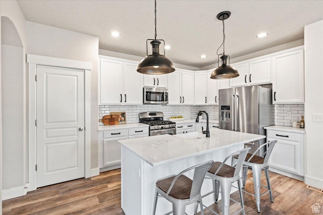 5153 W Bowstring Way S, Jordan, UT 84009 - kitchen featuring appliances with stainless steel finishes, wood finished floors, white cabinets, and recessed lighting